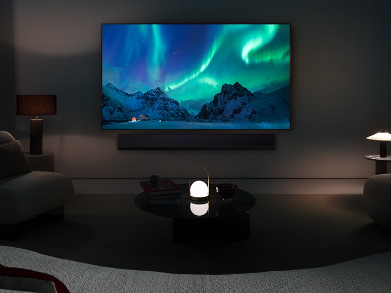 LG OLED TV and LG Soundbar in a modern living space in nighttime. The screen image of the aurora borealis is displayed with the ideal brightness levels.