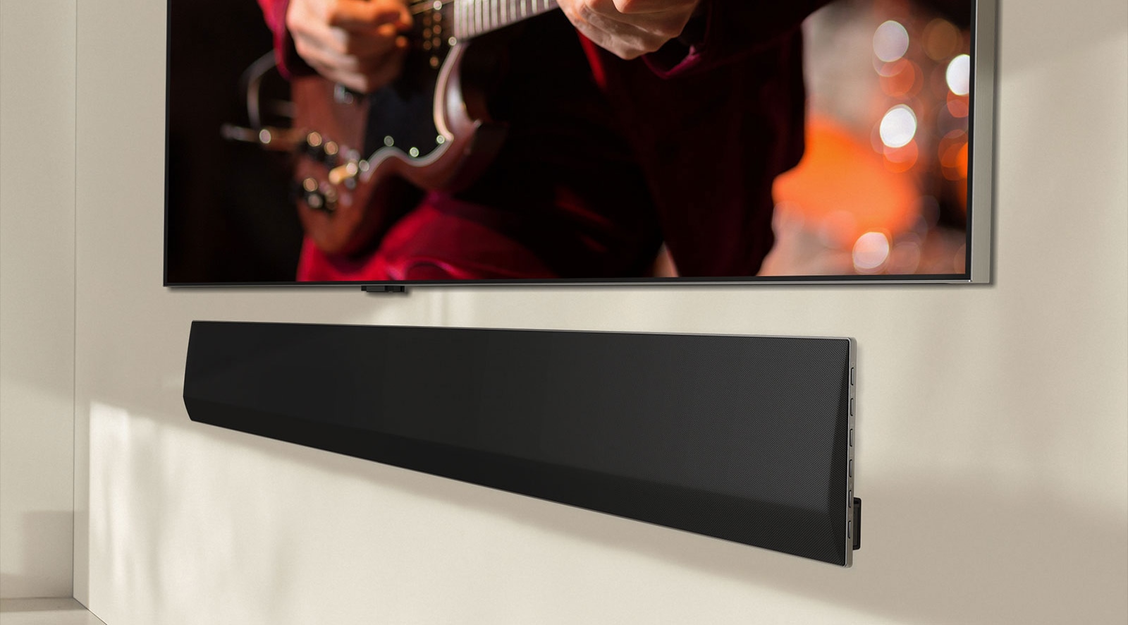 An image showing an angled view of the bottom of an LG OLED TV and LG Soundbar.