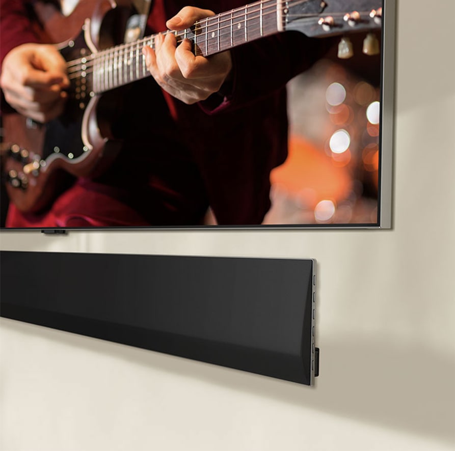 An image showing an angled view of the bottom of an LG OLED TV and LG Soundbar.