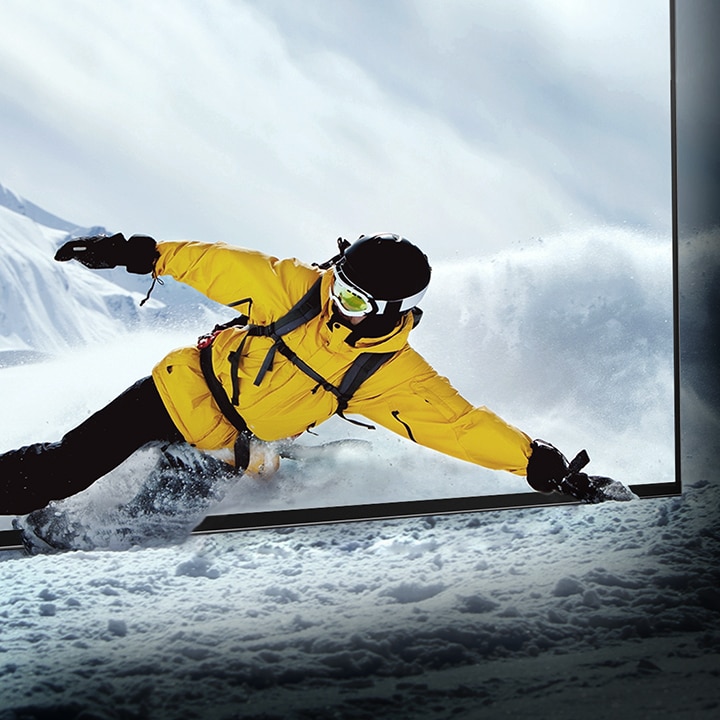 Un snowboardeur se penche sur l'écran de télévision LG OLED alors que la neige dans la pièce prend vie.