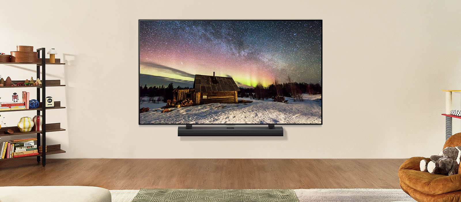 Uma imagem de uma TV e uma Soundbar da LG em um espaço de convivência moderno durante o dia. A imagem de uma aurora boreal é exibida com os níveis ideais de brilho.
