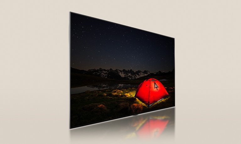 Um vídeo de uma LG TV com uma tela escura, exibindo uma cena de acampamento noturno com uma tenda vermelha brilhante. Um painel de luz de fundo azul se divide por trás da TV. Pequenos blocos de regulagem de luminosidade se dispersam pelo painel. Em seguida, o painel e a TV se fundem para tornar a tela mais brilhante e clara.