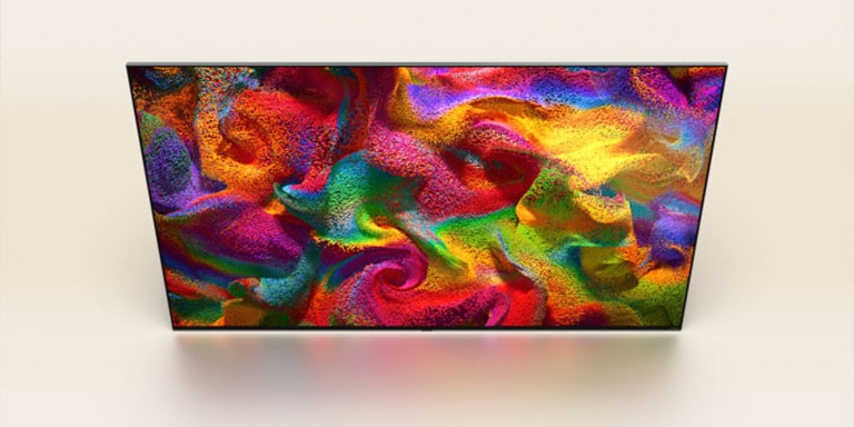 Um vídeo começa com partículas de cores explodindo, em seguida, os pixels mudam lentamente para um close-up de uma parede pintada com um padrão colorido na tela da LG TV.