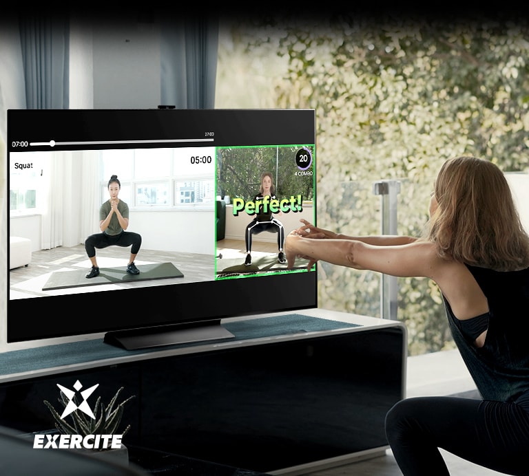 Uma mulher faz agachamento enquanto assiste à TV. Na tela da TV, aparecem imagens que ensinam o exercício e verificam a postura.