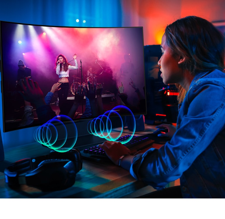 Image d’une personne regardant un concert sur un LG OLED Flex. Des bulles sonores décrivant les séquences audio sont émises à l’avant du téléviseur.