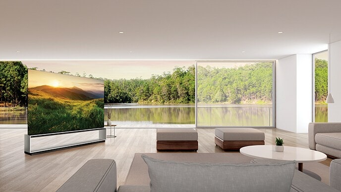 Le téléviseur LG SIGNATURE OLED 8K montre la vue sur la montagne sur son écran tout en étant posé dans le salon avec le paysage de verdure au-delà de la fenêtre.