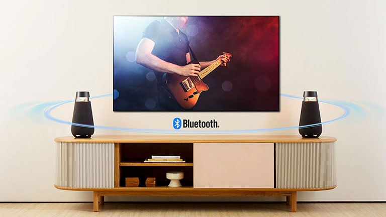 兩個 XO3 置於電視架上。使用藍牙將揚聲器連接到電視，將聲波傳送到客廳內各處。