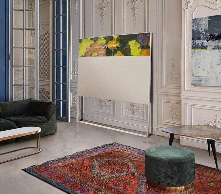 橫向顯示模式的 Easel 電視斜靠在設有裝飾鑄模的牆身上。電視位於牆上的一幅畫旁，前面是一張設計複雜的地毯。