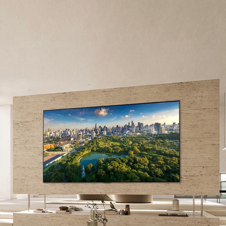 TV ultra besar terpasang di dinding dengan digantung di ruang tamu modern.