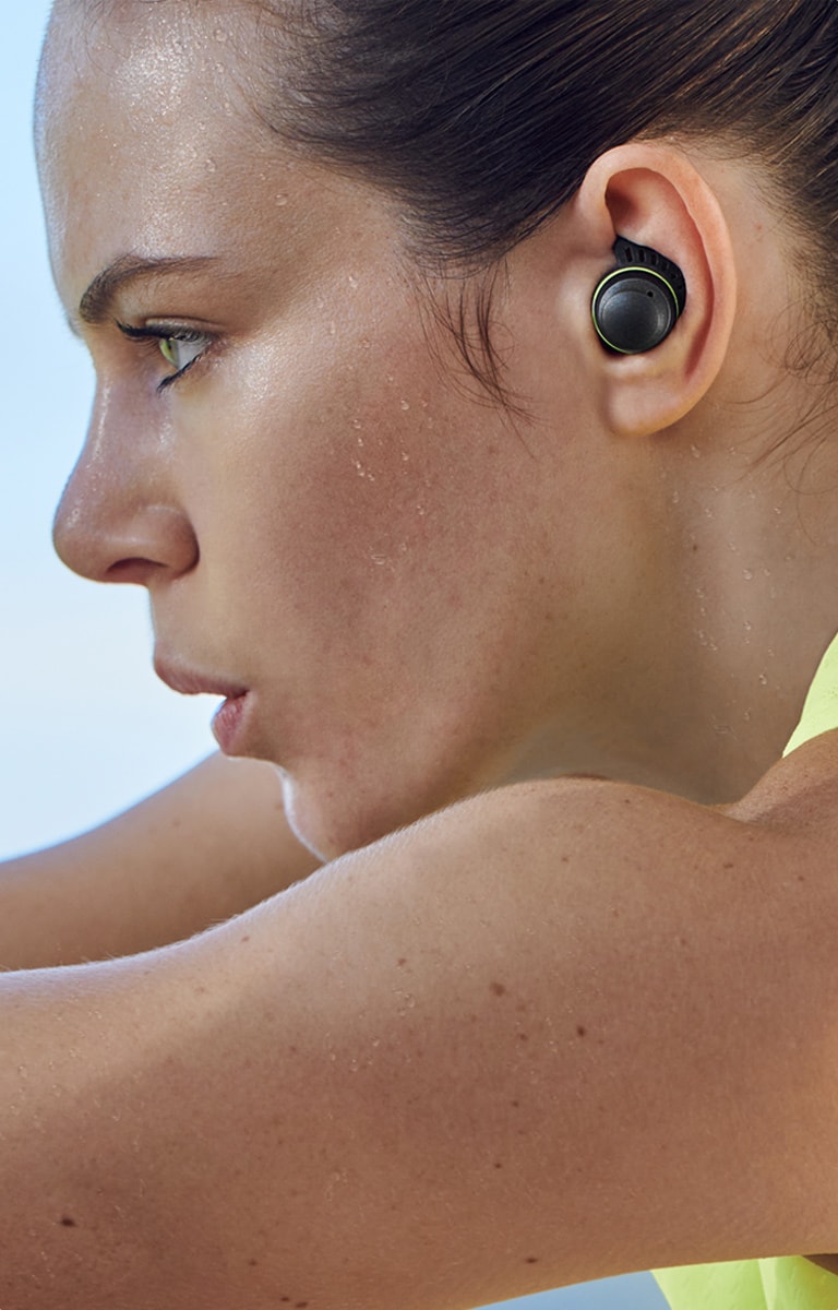 LG TONE-TF7Q A woman is sweating and working out with TONE Free fit earbuds.