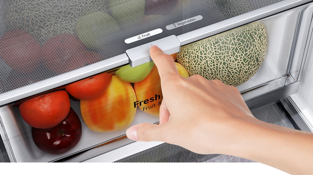 Los cajones inferiores del refrigerador están llenos de coloridos productos frescos. Una imagen insertada amplía la palanca de control para elegir el nivel de humedad óptimo para mantener los productos frescos.