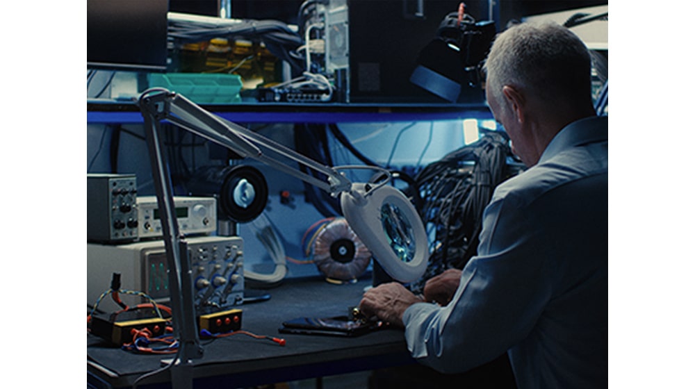 A man working on professional machines at his desk.