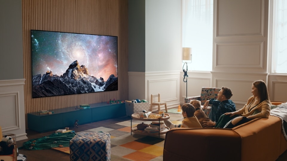 Eine Familie schaut Fernsehen über einen LG OLED TV in einem stylischen Wohnzimmer.