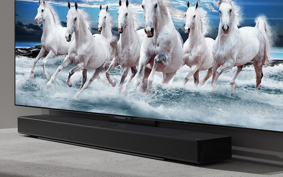 Eine schlanke Bluetooth-Soundbar passt perfekt zu einem LG-Fernseher, der ein Bild mit weißen Pferden zeigt