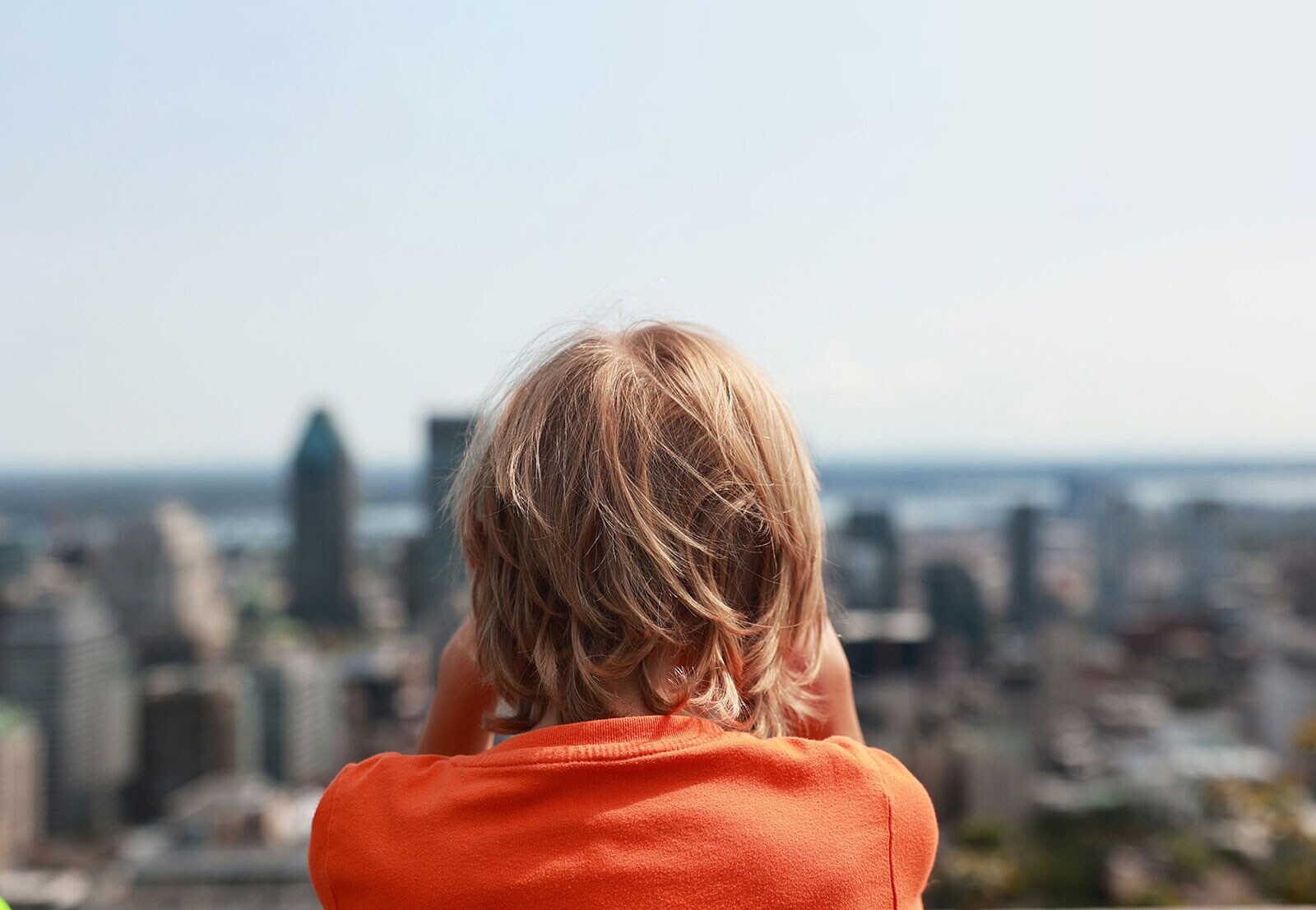 Ένα άτομο κοιτάει προς το αστικό τοπίο με ψηλά κτίρια και ουρανοξύστες.