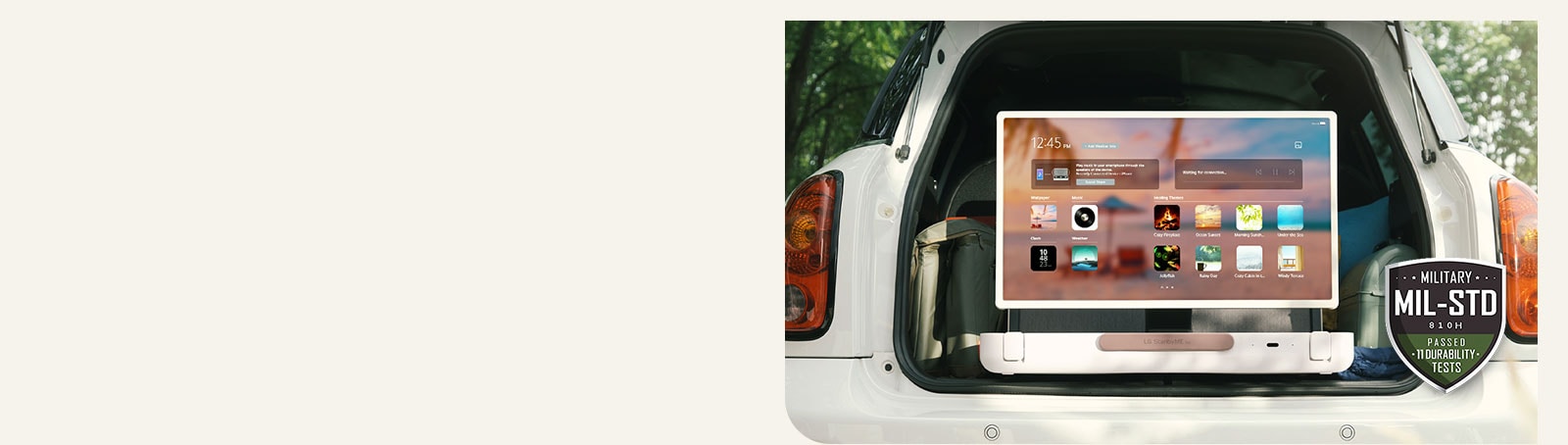 מבט קדמי על LG StanbyME Go. המוצר מונח במכונית, המסך במצב אופקי ומציג את מסך הבית. בצידה השמאלי התחתון של התמונה מוצג סמל של סטנדרט צבאי.