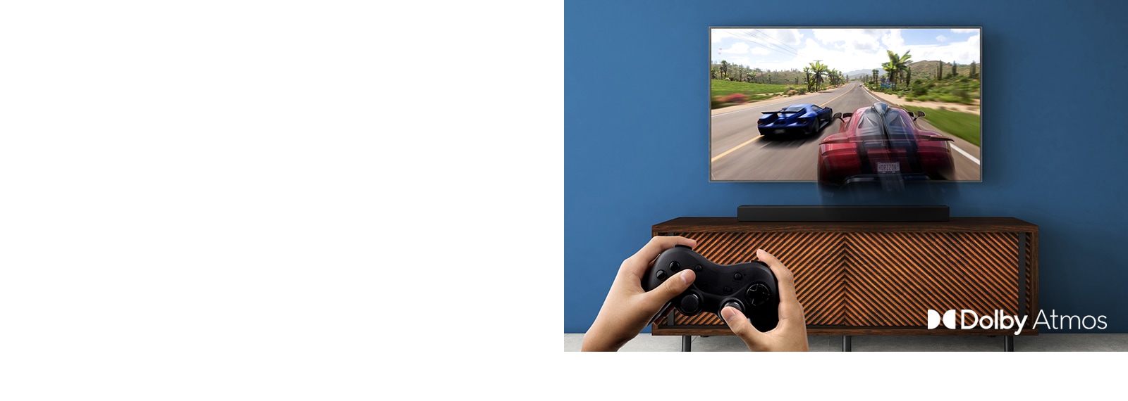 LG-TV-en henger på veggen og viser et racerspill. LG-lydplanken er plassert på den brune hylla rett nedenfor LG-TV-en. En mann holder en spillkontroll.