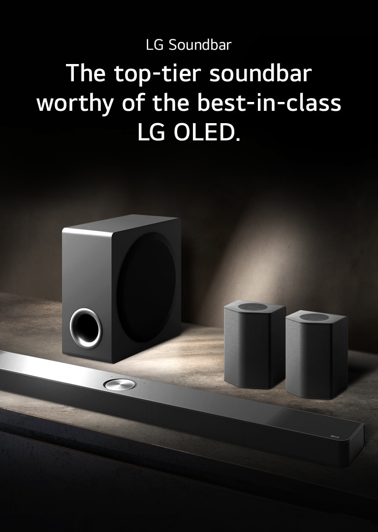 LG Soundbar, rear speakers, and subwoofer are placed within an angled perspective on a brown wooden shelf in a black room, enveloped in darkness with light only casting over the sound system.