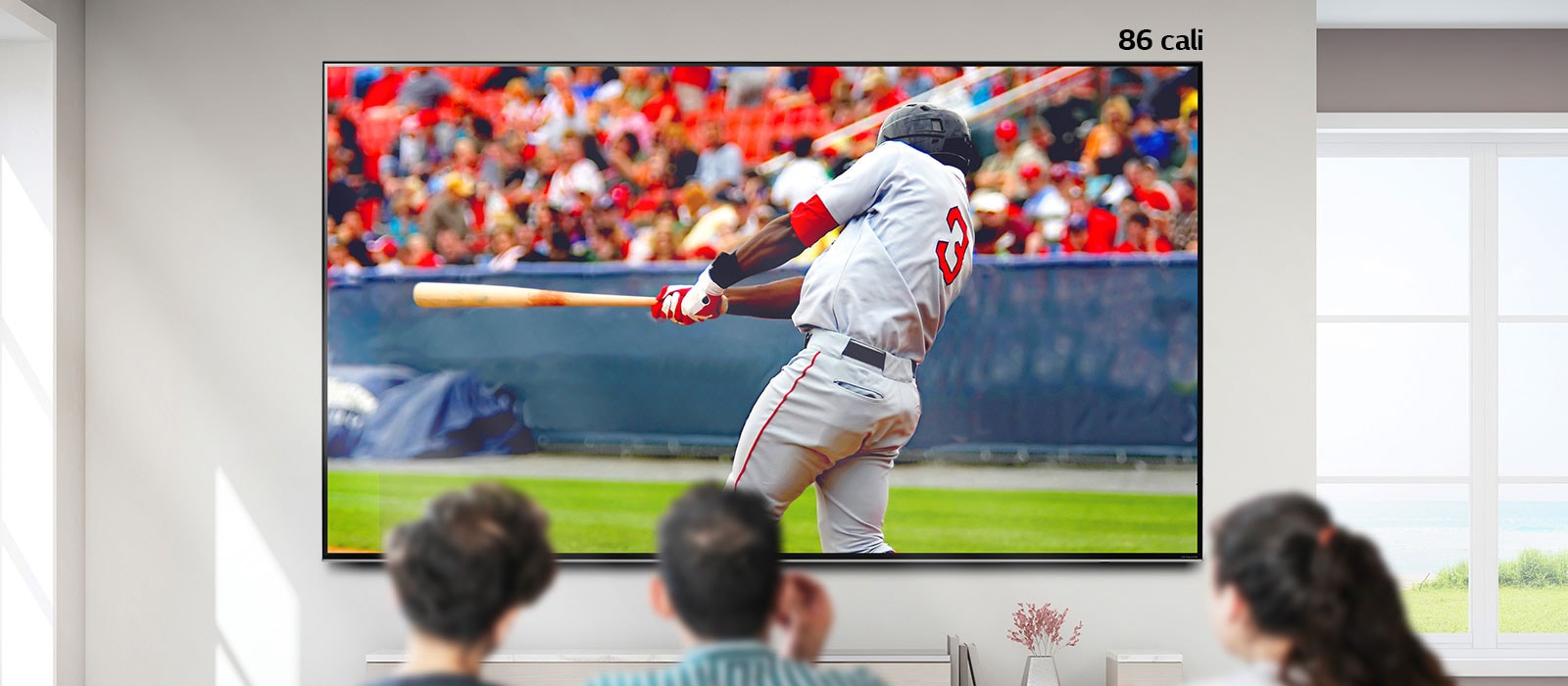 Przewijany obraz przedstawiający trzy osoby oglądające bejsbol na dużym telewizorze zawieszonym na ścianie. Przewijanie w prawo powoduje powiększanie się ekranu.