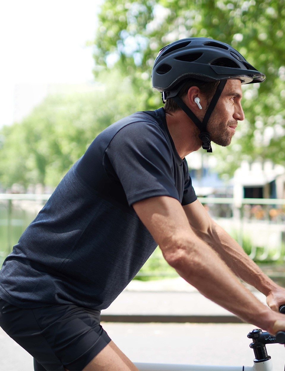 Mężczyzna jadący na rowerze z dźwiękowymi wkładkami dousznymi
