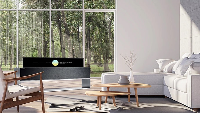 LG SIGNATURE R in a white-themed room in front of a large window with a view of a forest