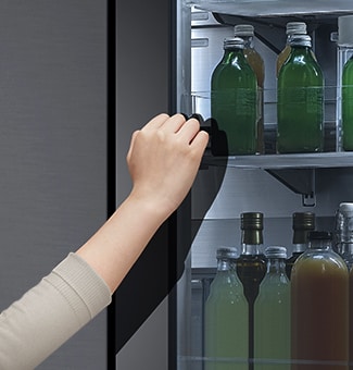 Hình ảnh phía trước của tủ lạnh InstaView kính màu đen với đèn bên trong. Bàn tay đang chạm vào màn hình InstaView.