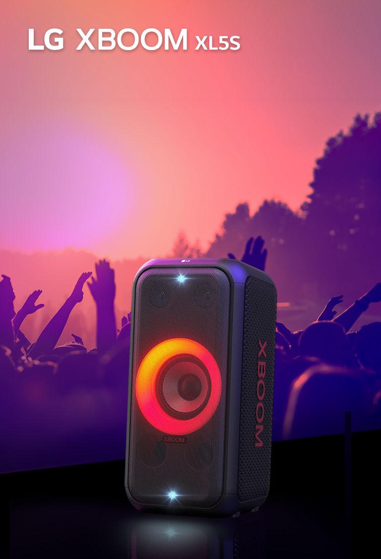 LG XBOOM XL5S trên sân khấu chiếu ánh sáng hòa trộn đỏ và cam. Sau sân khấu, mọi người đang tận hưởng âm nhạc.