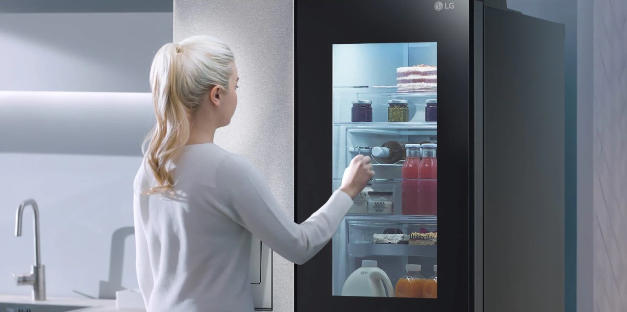 Hình ảnh một người phụ nữ nhìn tủ lạnh có ngăn đông lạnh.